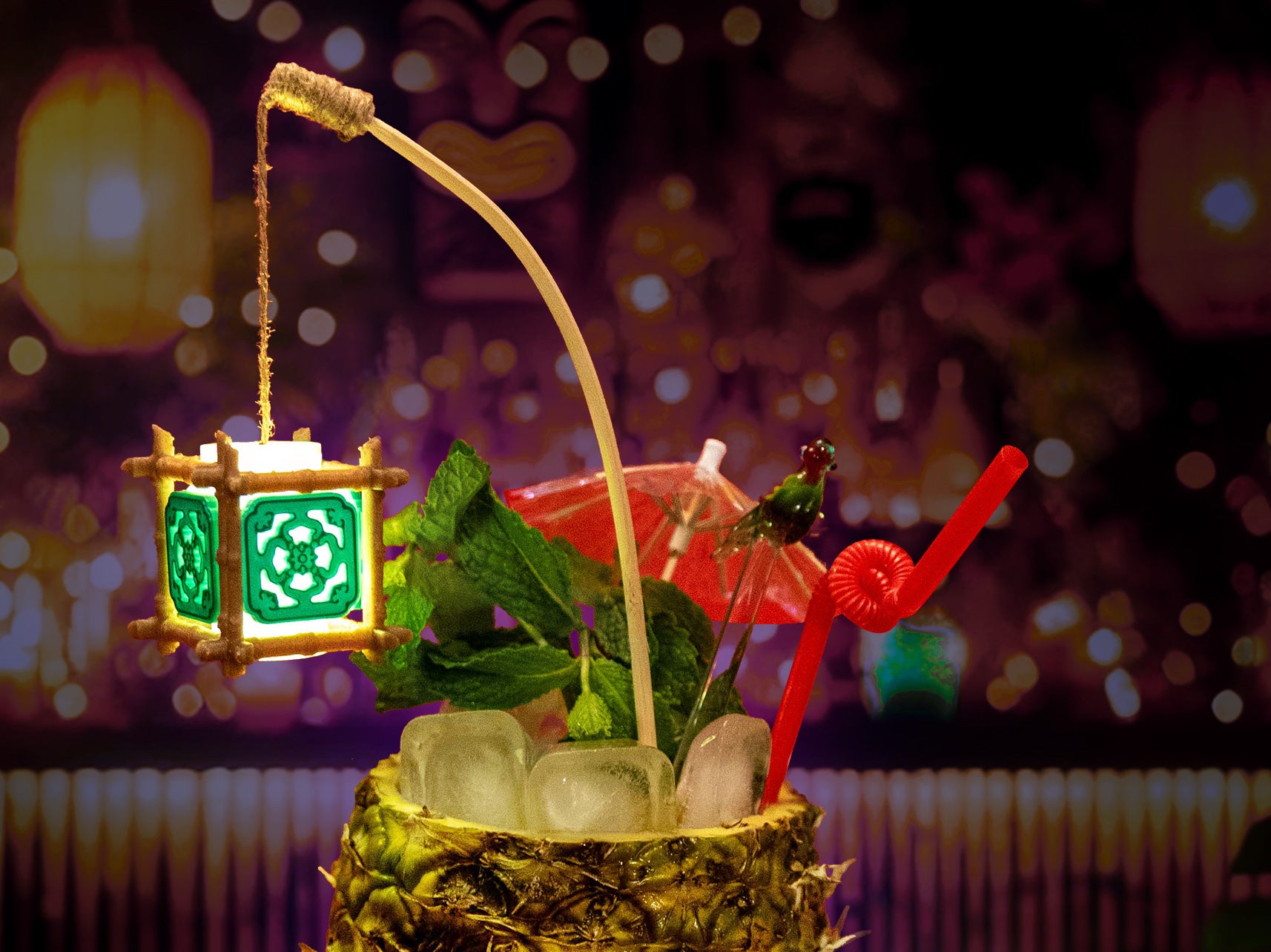 Close-up of tiny glowing tiki lamp swizzle with bamboo cage