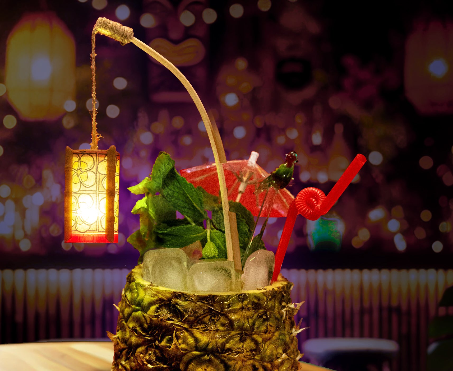 Mini tiki lantern swizzle stick glowing inside a tropical cocktail